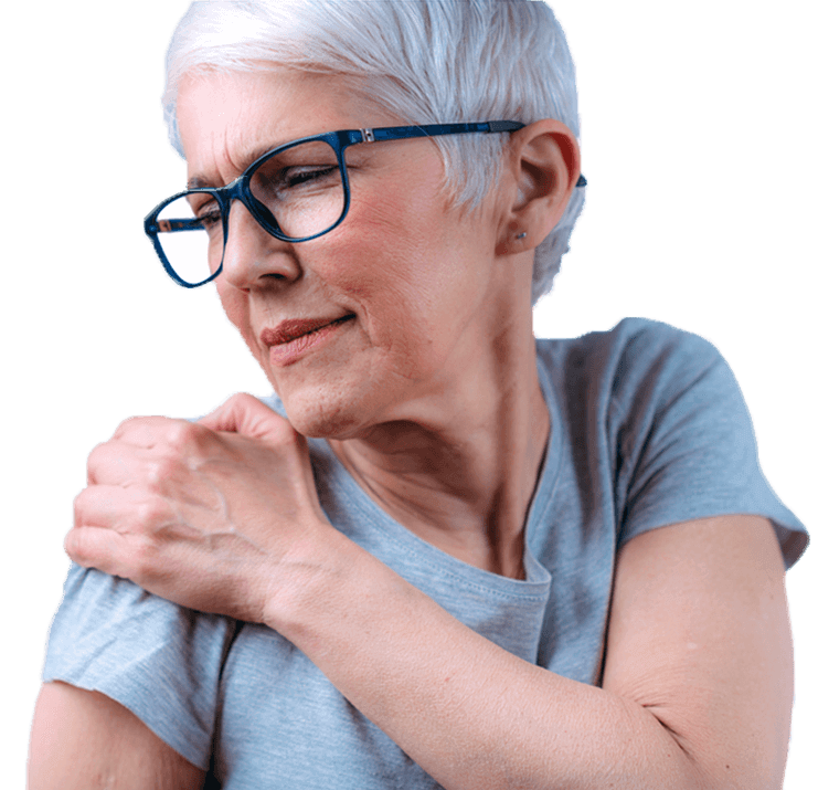 Older woman holding her shoulder in discomfort, indicating joint pain.