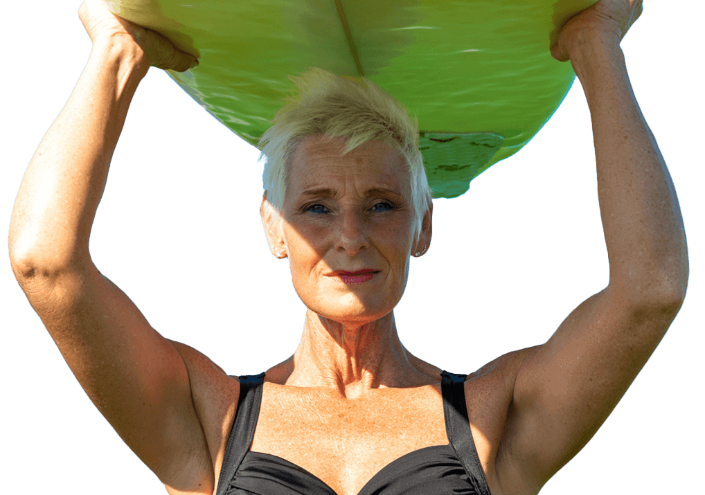 Older woman holding surfboard above her head, symbolizing vitality and strength at any age