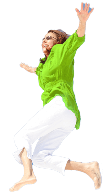Happy woman jumping barefoot in white trousers and green blouse, expressing freedom