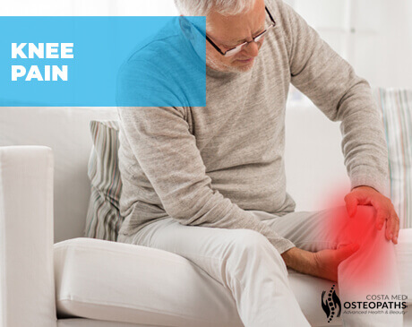 Older man sitting on a sofa holding his painful knee, highlighted in red to indicate discomfort.